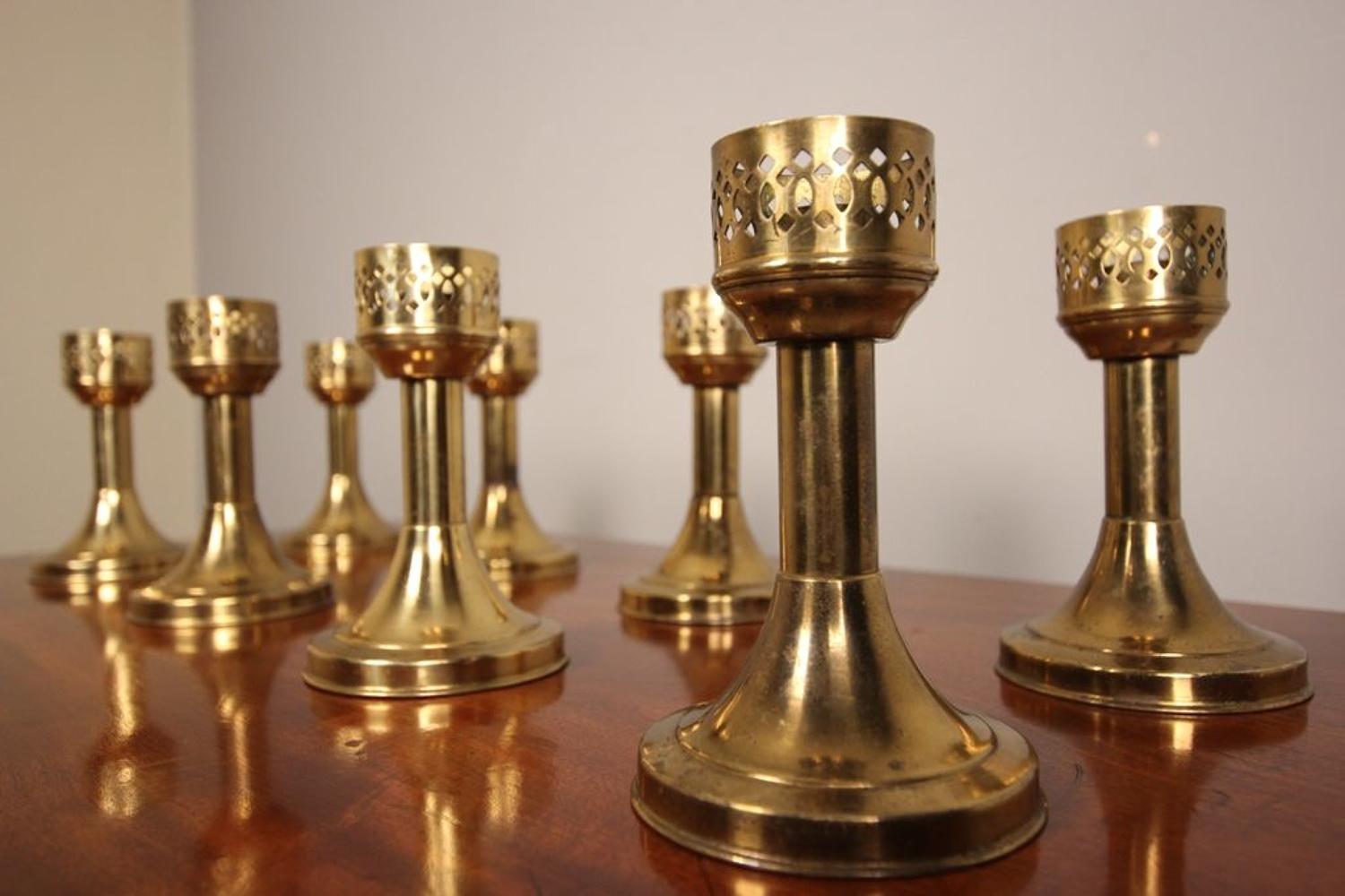 A Run of 8 Decorative Brass Candlesticks
